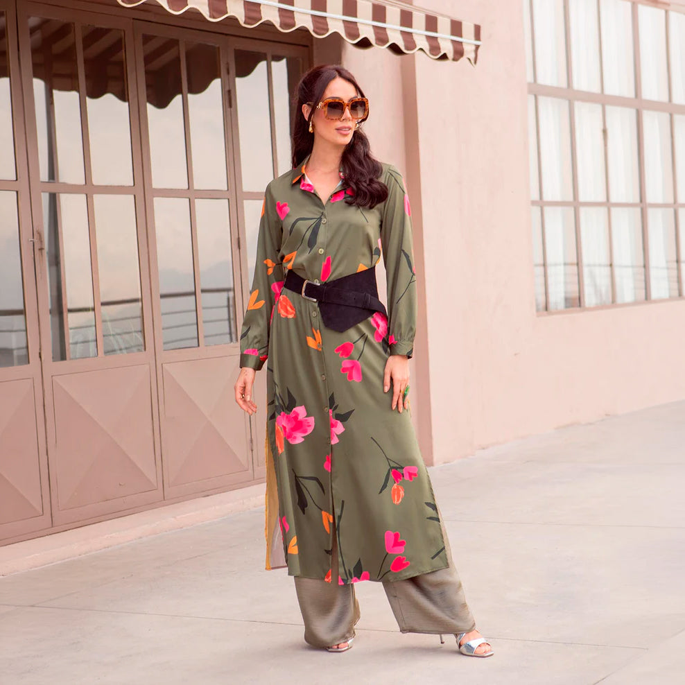 Mujer con vestido estampado floral de media pierna, en un fondo neutro con luz natural